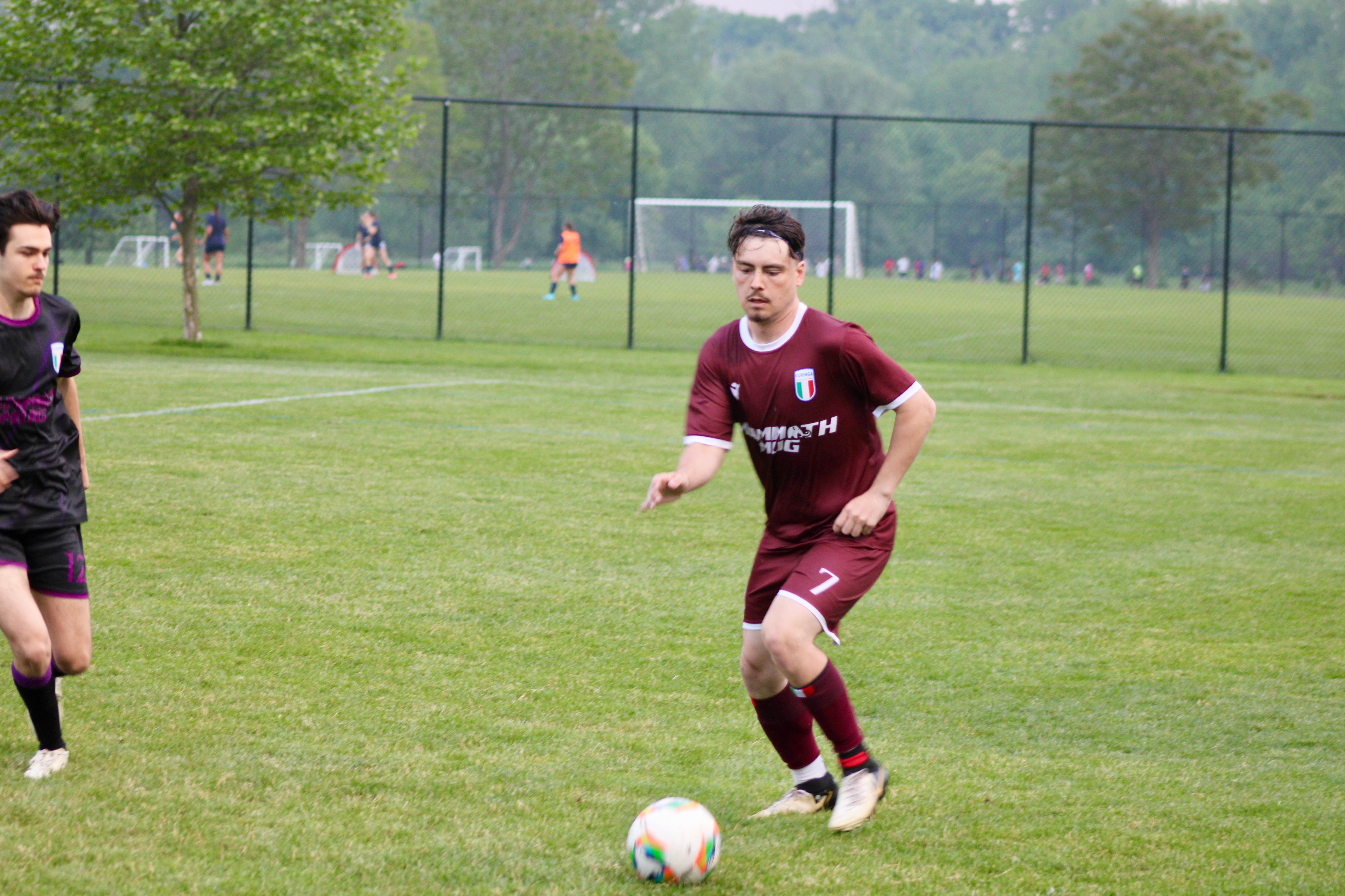 Buringa FC player (#7) with Mammoth Mug sponsor dribbling the ball during outdoor match
