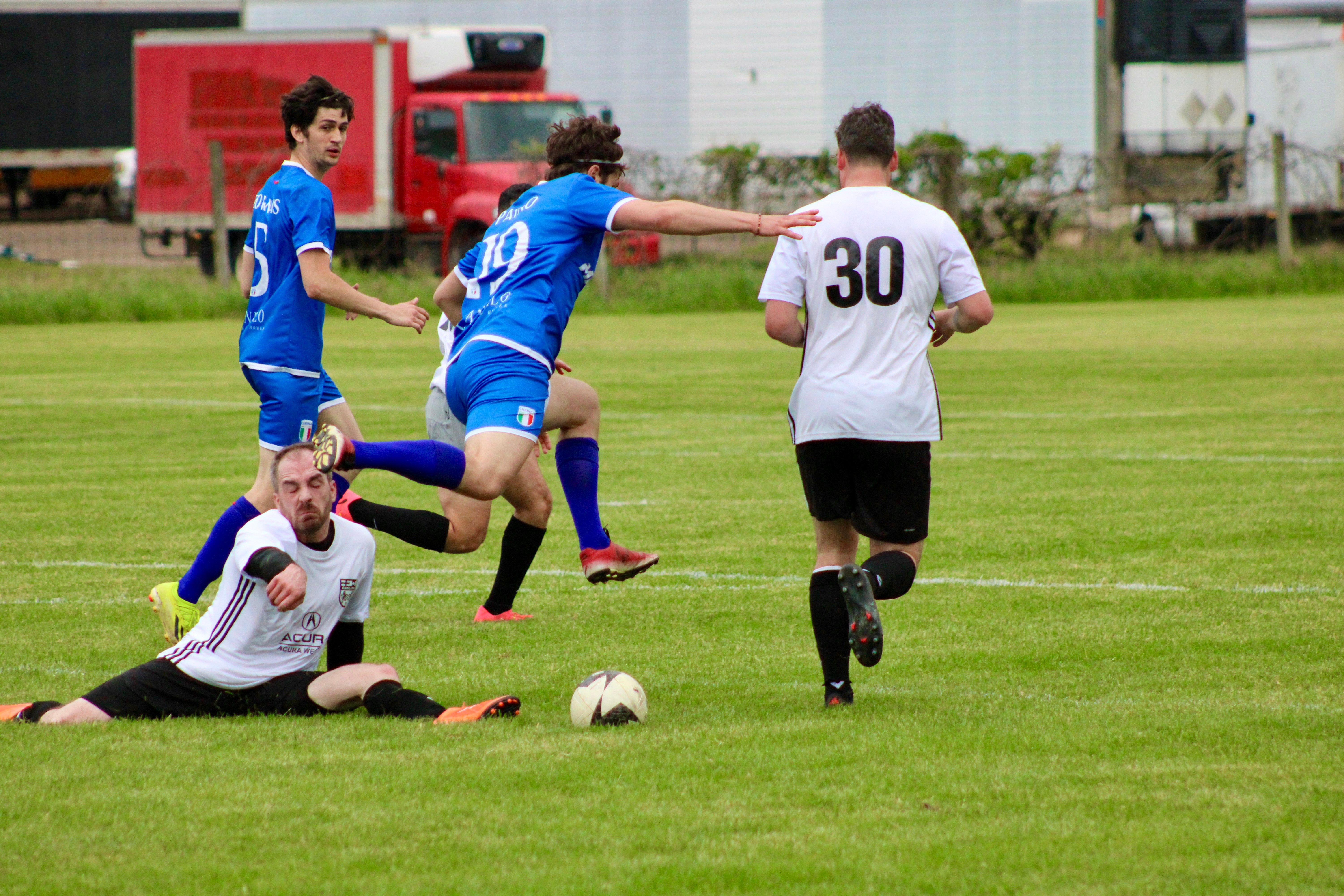 Intense match action with Paino (#19) and Curinga FC players