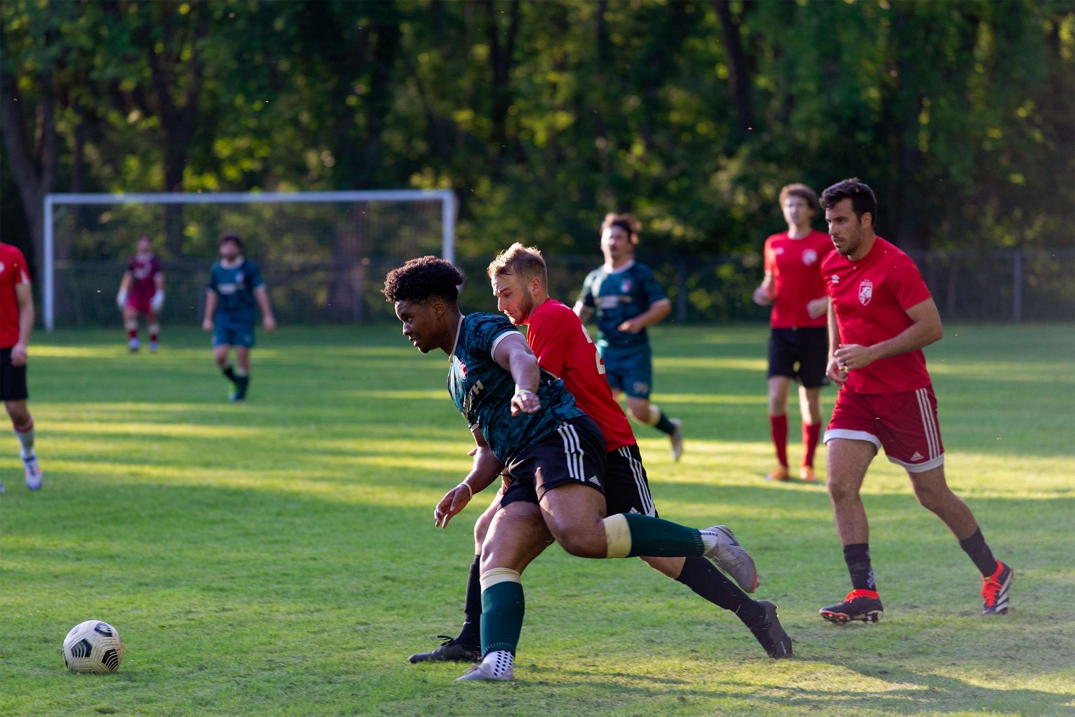 Curinga FC player battling for the ball against opponent in red