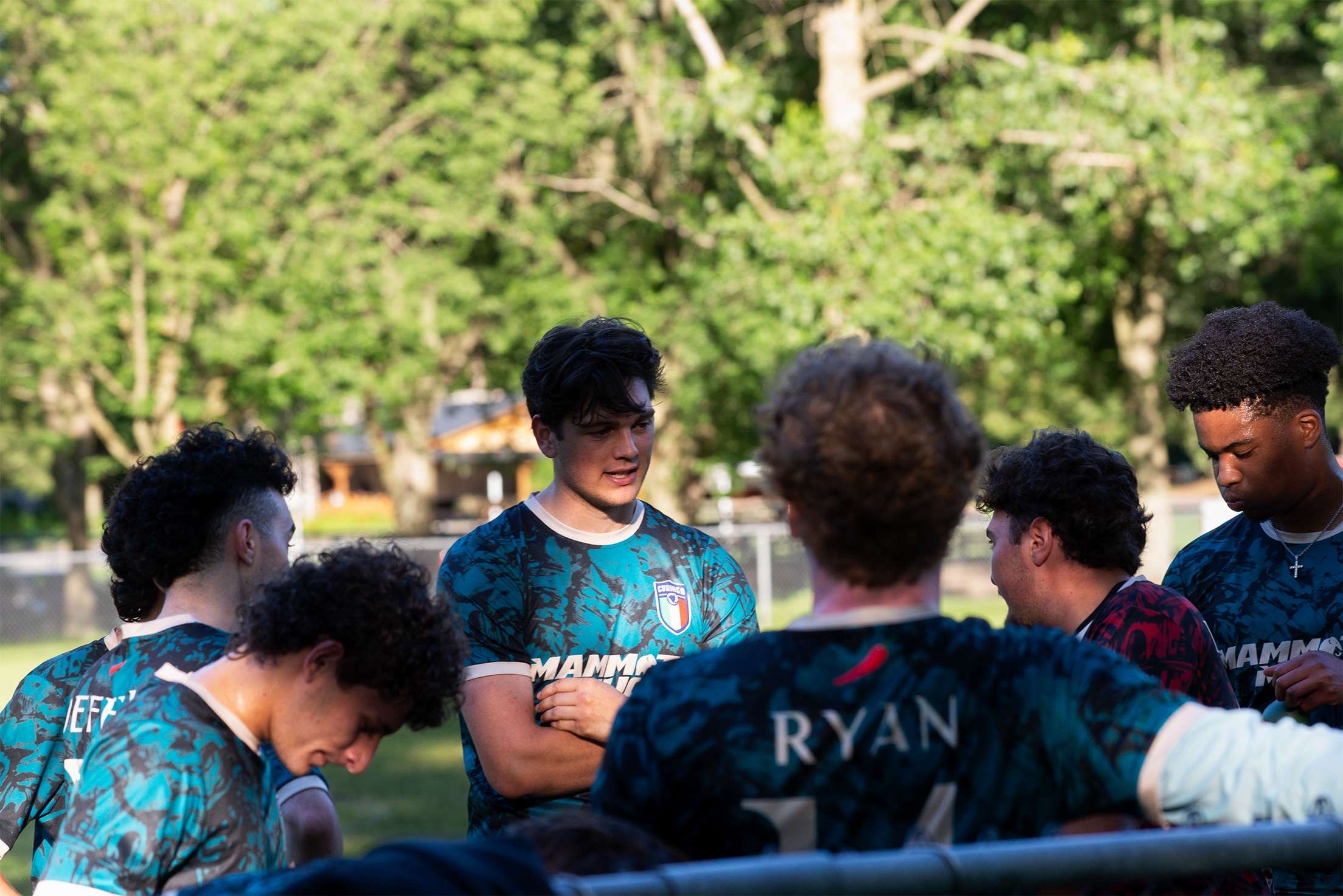 Curinga FC team huddle in teal jerseys