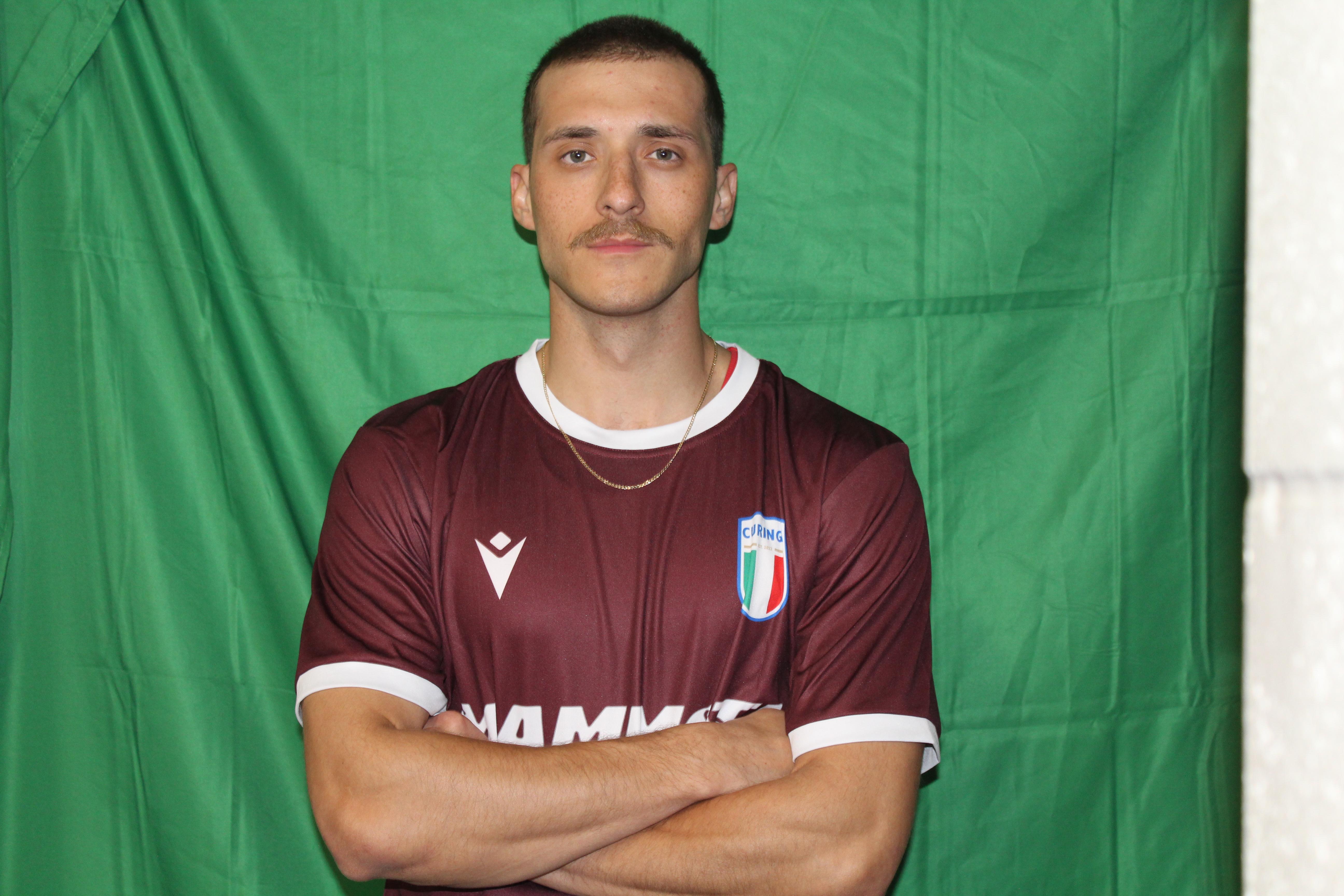 Buringa FC player with arms crossed in maroon jersey