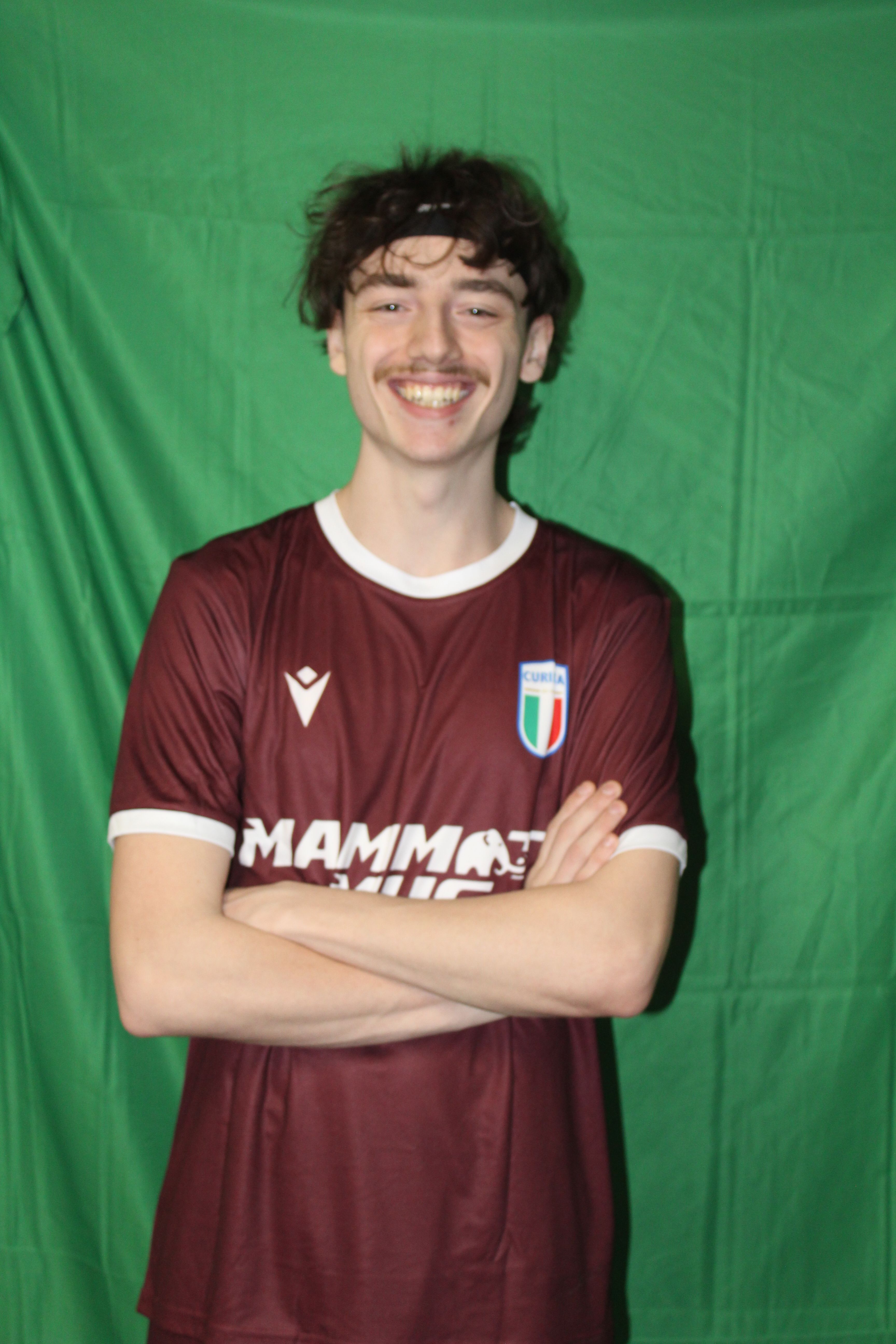 Buringa FC player smiling with arms crossed in team jersey